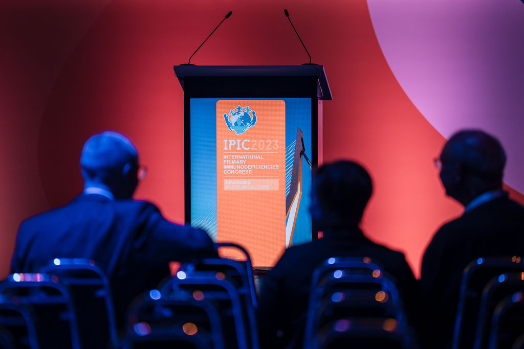 IPIC2023: View of a row of conference attendees and the podium captured from the back.