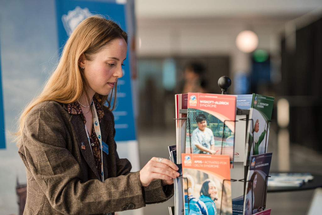 IPIC2023: Woman looking at a display of conference pamphlets.