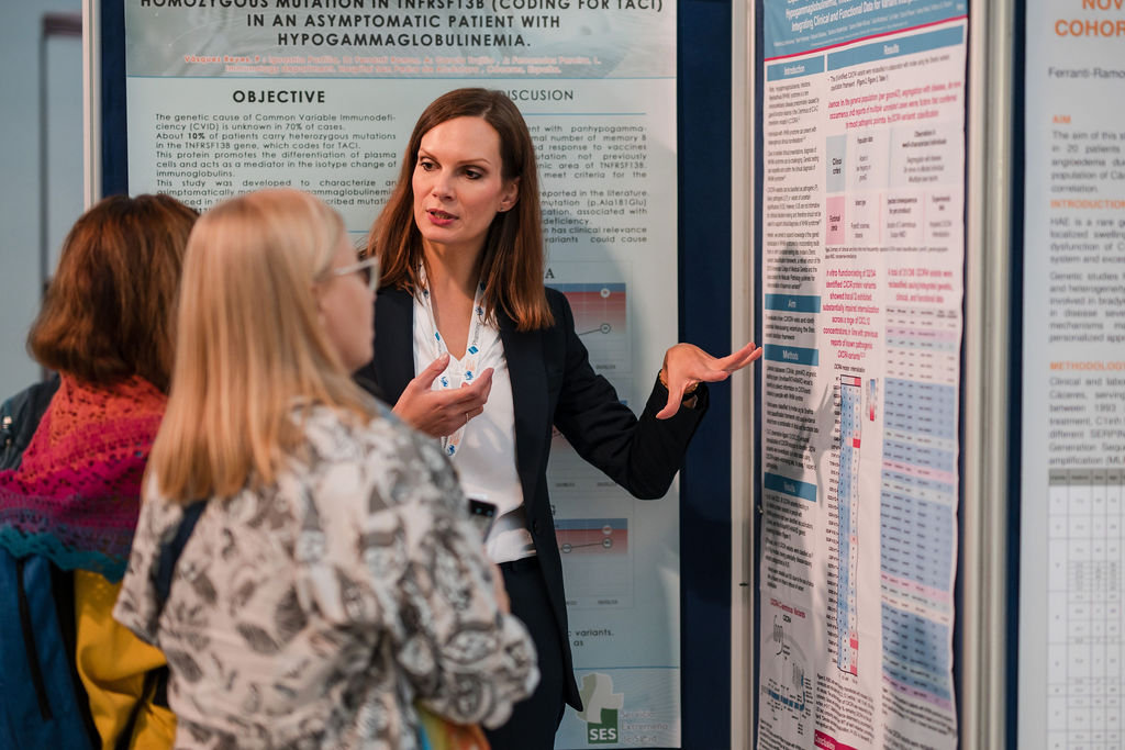 A woman in business attire presents research posters to two attendees at a IPIC 2025.